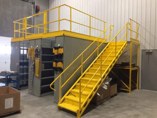 Yellow mezzanine staircase in a warehouse setting.